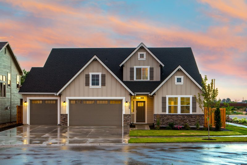 A two story house with a rain-soaked driveway featuring sign lights at dusk - Shop C2CLights.com.